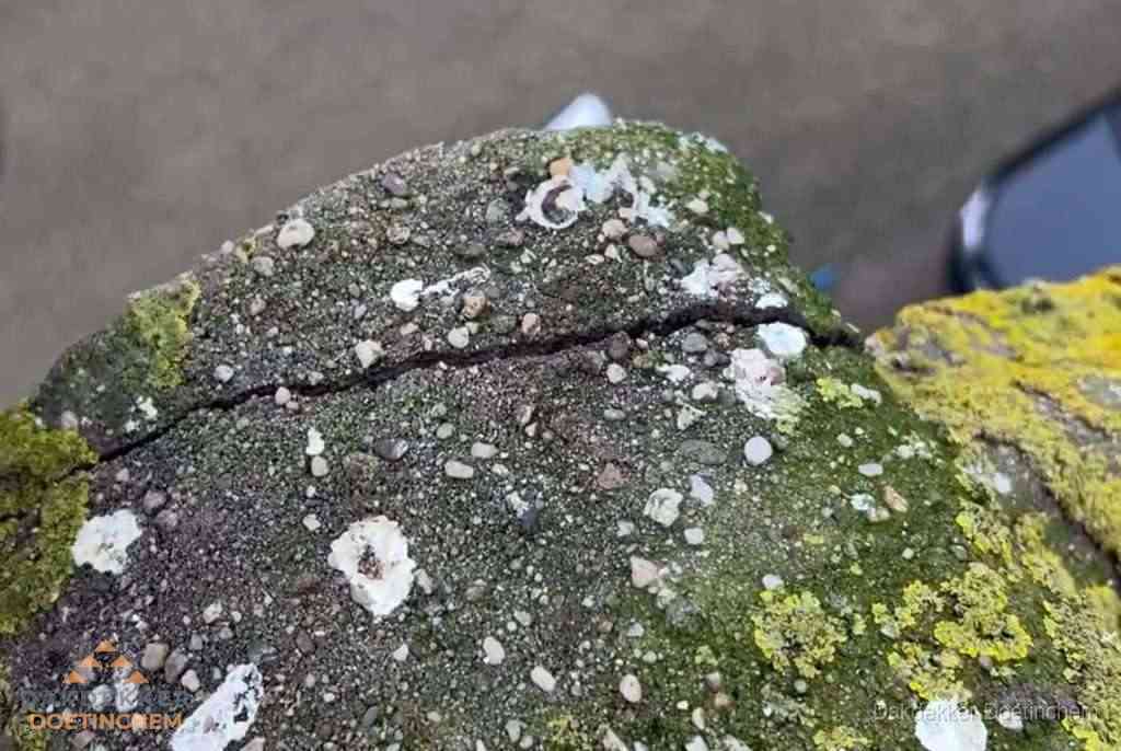 Beschadigde en verweerde nokvorst met scheuren en mos in Doetinchem
