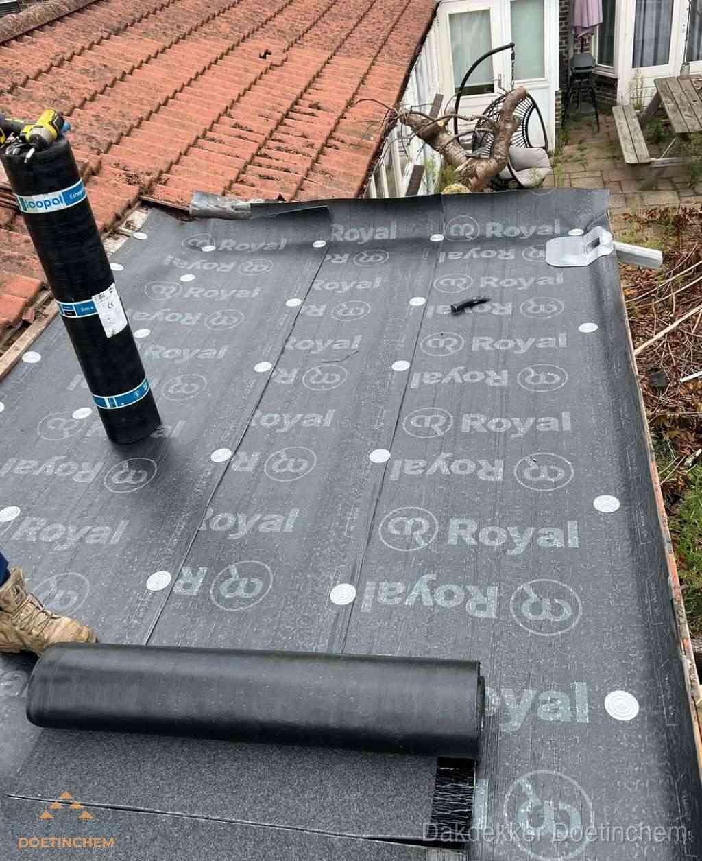 Plat dak met nieuwe bitumen dakbedekking en brandgereedschap in Doetinchem