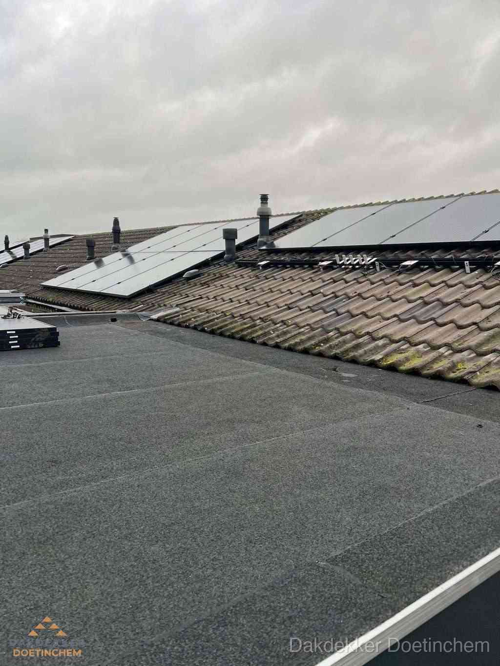 Plat dak inspectie met bitumen bedekking naast schuin pannendak in Doetinchem