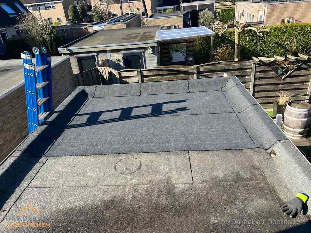 Dakdekker legt onderlaag op plat dak met houten constructie in Doetinchem