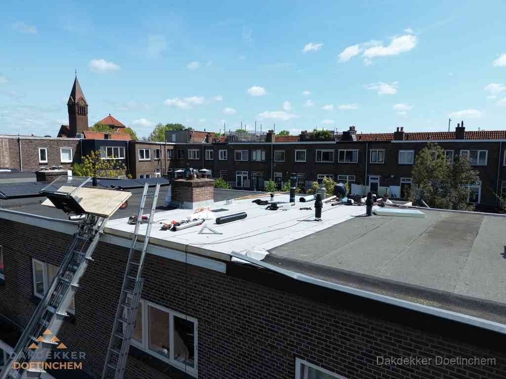 Dakdekkers aan het werk op plat dak in Doetinchem
