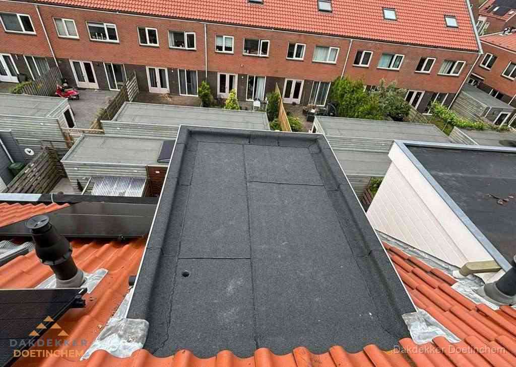 Plat dak met bitumen bedekking naast dakkapel in Doetinchem