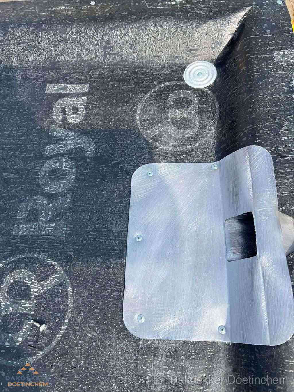 Dakdoorvoer met metalen afvoerplaat op bitumen dak in Doetinchem