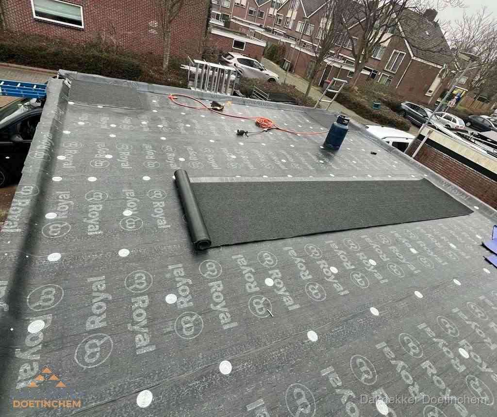 Dakdekker aan het werk met gasbrander op plat bitumen dak in Doetinchem