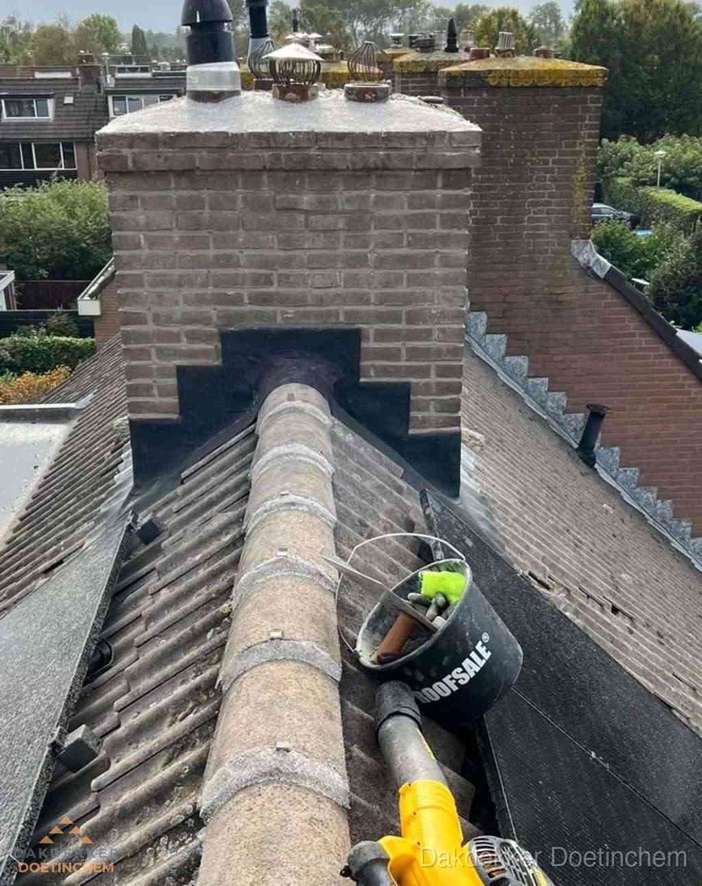 Dakdekker repareert bitumen dakleer bij dakdoorvoer in Doetinchem